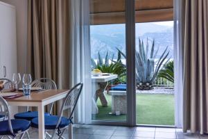 a dining room with a table and a view of a garden at Hotel Roma Aparthotel in Malcesine
