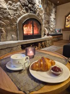 a table with a plate of croissant and a cup of coffee at Der Bären in Zell in Eisenberg