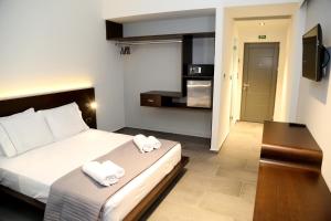 ein Schlafzimmer mit einem Bett mit zwei Handtüchern darauf in der Unterkunft Megara Hotel in Megara