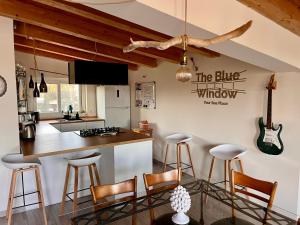 a kitchen with bar stools and a kitchen with a guitar on the wall at The Blue Window - Apartment - 300m from sea in Augusta