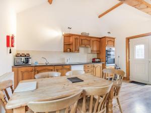a kitchen with a wooden table and chairs at Leedale Cottage in Saltmarshe