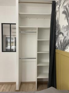 a closet with white shelves and a mirror at Cozy Studio with Terrace in Cers