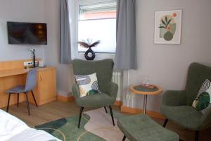 a bedroom with two chairs and a table and a window at Hotel und Gasthaus Sieling in Liebenau