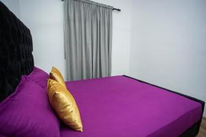 a purple bed with gold pillows in a bedroom at Villa Ceilaoo in Galle