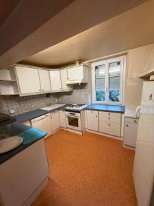 a kitchen with white cabinets and an orange floor at La casa del camino in Montréal