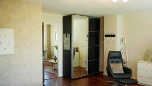 a room with a black chair and a mirror at Casa Vista Duna - Kijkduin in The Hague