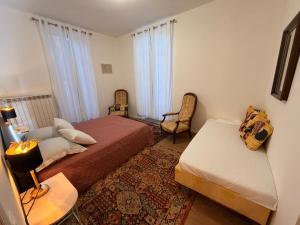 a bedroom with two beds and a chair and a table at La casa del camino in Montréal