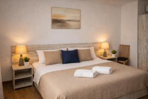 a bedroom with a large bed with two towels on it at Casa Elis Piscina, Jacuzzy , Sauna, Ciubar in Merei +51 photos