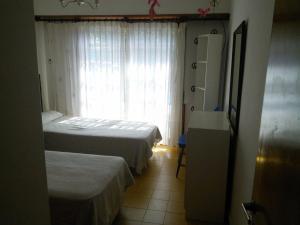 a small room with two beds and a window at Chalet con pileta in Miramar +13 photos