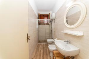 a bathroom with a sink and a toilet and a mirror at Il Bacio del Sole - San Foca in San Foca +20 photos