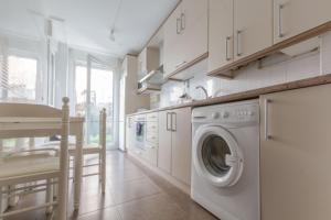 a kitchen with a washer and dryer in a room at Gibaja Apartmento con Jardin in Gibaja