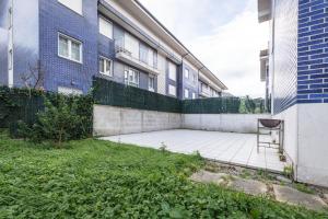 a chair sits on a patio in front of a building at Gibaja Apartmento con Jardin in Gibaja