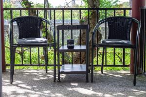 two black chairs sitting next to a fence at Apartman Gajnice Zagreb in Zagreb