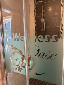 a bathroom with a shower with a sign on the door at Egglmeier's Ferienwohnung in Grundlsee