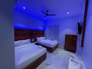 a bedroom with two beds and a blue ceiling at Hotel Midnight Lodging & Boarding in Panvel +11 photos