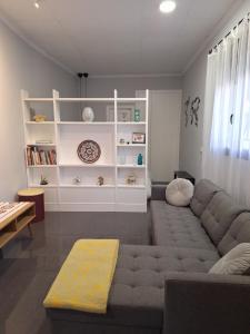 a living room with a gray couch and white shelves at LOFT La Placeta in Enguera