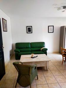 a living room with a green couch and a coffee table at Houlgate T2 bis in Houlgate +4 photos