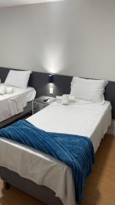two beds sitting next to each other in a room at Seu Hotel in Patos