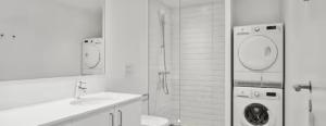a bathroom with a sink and a washing machine at Beach View Apartment in Vallensbæk in Vallensbæk