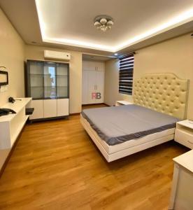 a bedroom with a large bed and a kitchen at Rathore villa in Lahore