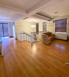 a living room with a couch and wooden floors at Rathore villa in Lahore