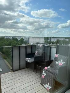 a balcony with two chairs and a table on a deck at Beach View Apartment in Vallensbæk in Vallensbæk