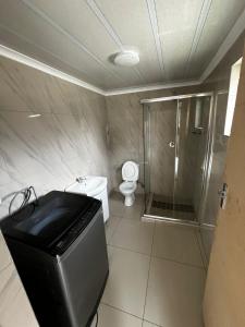 a bathroom with a shower and a toilet in it at Sunset Rest Guesthouse in Secunda