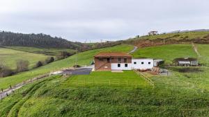 a house on a hill with a green field at Finca Seles in Ajo