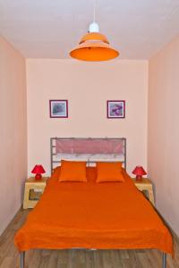 エカテリンブルクにあるALLiS-HALL Apartament at Karla Libkknekhta 16のベッドルーム1室(オレンジのシーツとランプ2つ付)
