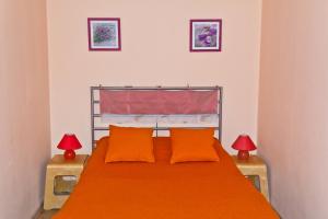 a bedroom with a bed with orange sheets and two lamps at ALLiS-HALL Apartament at Karla Libkknekhta 16 in Yekaterinburg