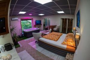 a bedroom with a large bed and a living room at E14 apartman in Berekfürdő