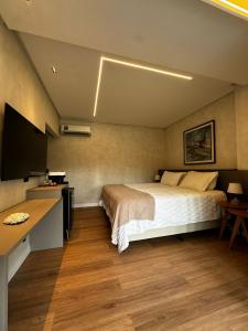 a bedroom with a bed and a desk and a television at Amélia Pousada de Charme in Porto De Galinhas +19 photos