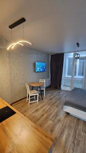 a living room with a table and a bed at 1 комнатные апартаменты 4а 67 in Semey