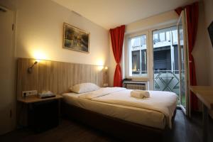 a hotel room with a bed and a window at Hotel Paris in Düsseldorf