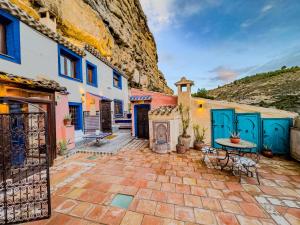 a house with blue doors and a stone courtyard at XUQ Hotels Alaxara in Cubas +49 photos