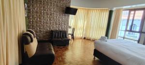 a bedroom with a bed and a couch and a window at Hotel RustiCall in La Paz