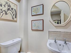 a bathroom with a toilet and a sink and a mirror at 1 Bed in Alnwick oc-95776 in Chillingham +14 photos