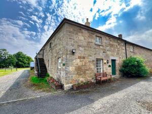 a brick building with a bench in front of it at 1 Bed in Alnwick oc-95776 in Chillingham