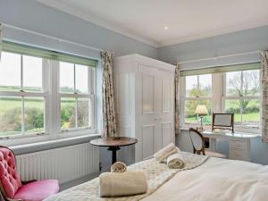 a bedroom with a bed and a desk and windows at 2 Bed in Dorchester oc-59666 in Long Bredy