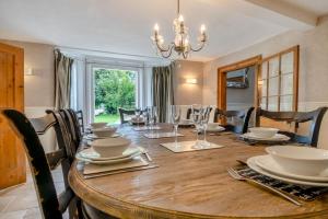 a dining room with a wooden table with chairs and a chandelier at 5 Bed in Bramfield oc-sftmh in Bramfield