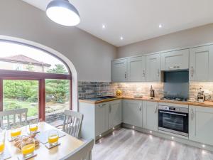 a kitchen with white cabinets and a table with chairs at 2 Bed in Toft Hill oc-80003 in High Etherley