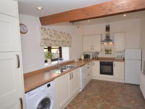 a kitchen with white cabinets and a washer and dryer at 2 Bed in Chew Magna oc-56550 in Stowey +11 photos