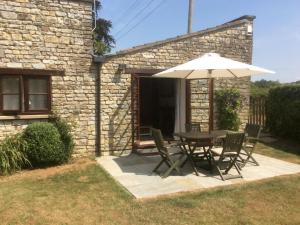 a table and chairs with an umbrella on a patio at 2 Bed in Chew Magna oc-56550 in Stowey