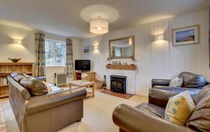a living room with leather furniture and a fireplace at 3 Bed in Braunton oc-salar in Georgeham
