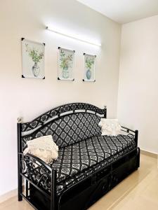 a black bed in a room with pictures on the wall at A La Mer - Solis 3 in Varca