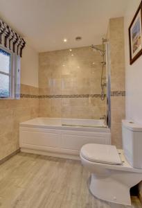 a bathroom with a bath tub and a toilet at 3 Bed in Braunton oc-salar in Georgeham +19 photos