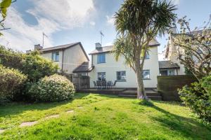 a white house with a palm tree in the yard at 3 Bed in Braunton oc-salar in Georgeham