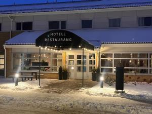 ein Hotelrestaurant mit einer Bank vor einem Gebäude in der Unterkunft Hotel Tingsryd in Tingsryd + 3 Fotos