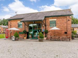 a brick building with two benches and umbrellas at 2 Bed in Ripon oc-85510 in Masham