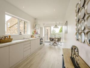 a kitchen with white cabinets and a dining table at 2 Bed in Northallerton oc-83398 in Brompton
